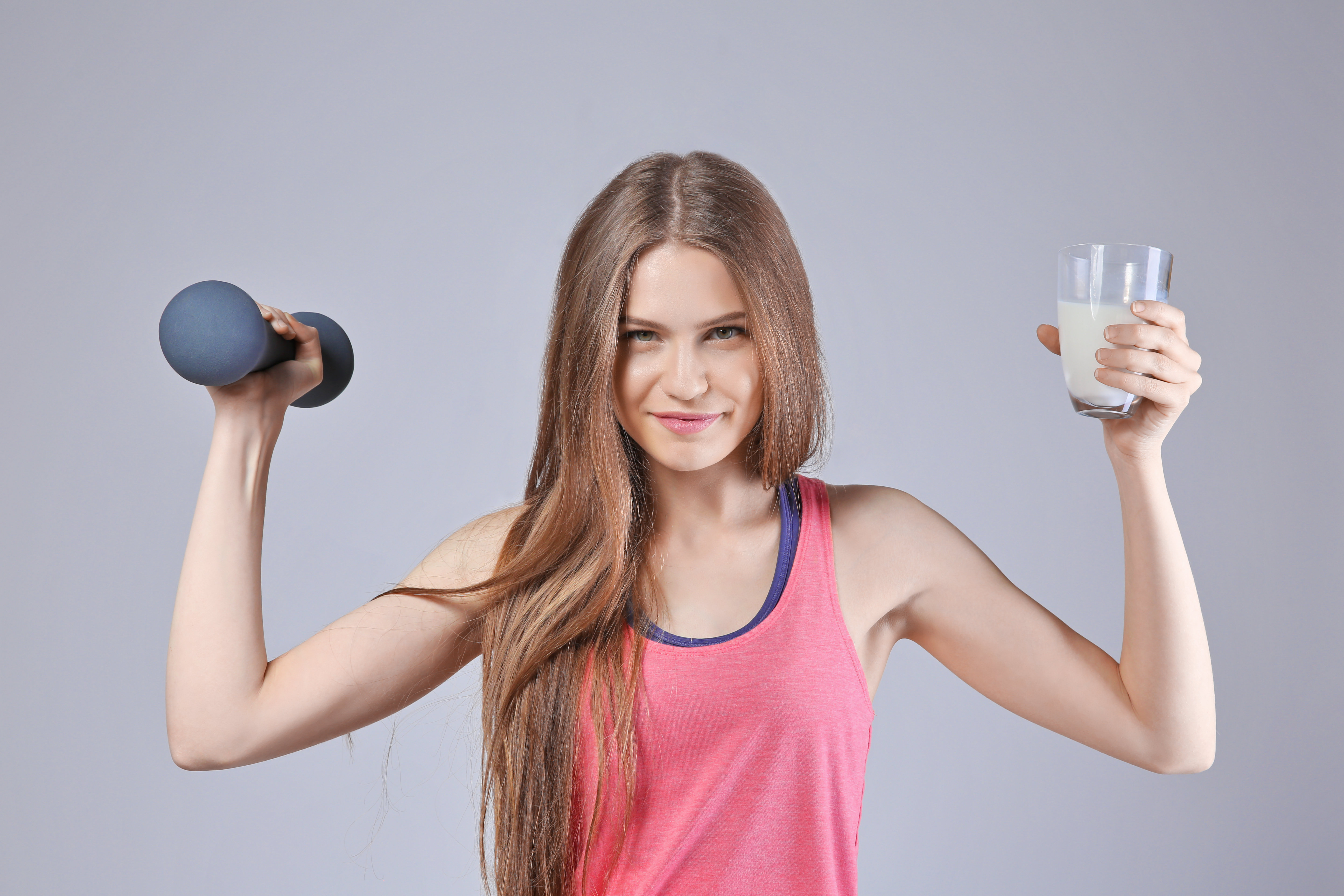 woman with glass of milk and dumbbell