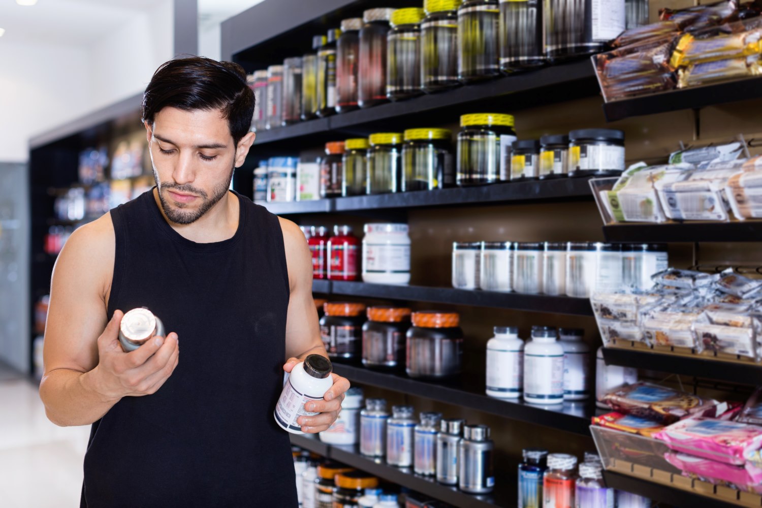 Man reading the label of a pre-workout supplement