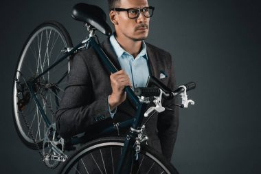 man in suit holding a bike