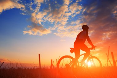 cyclist riding into the sun