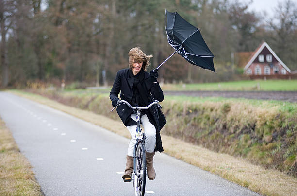 lady riding in rain with broken umbrella