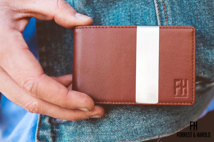 Forrest and Harold brown wallet held beside a man's pocket
