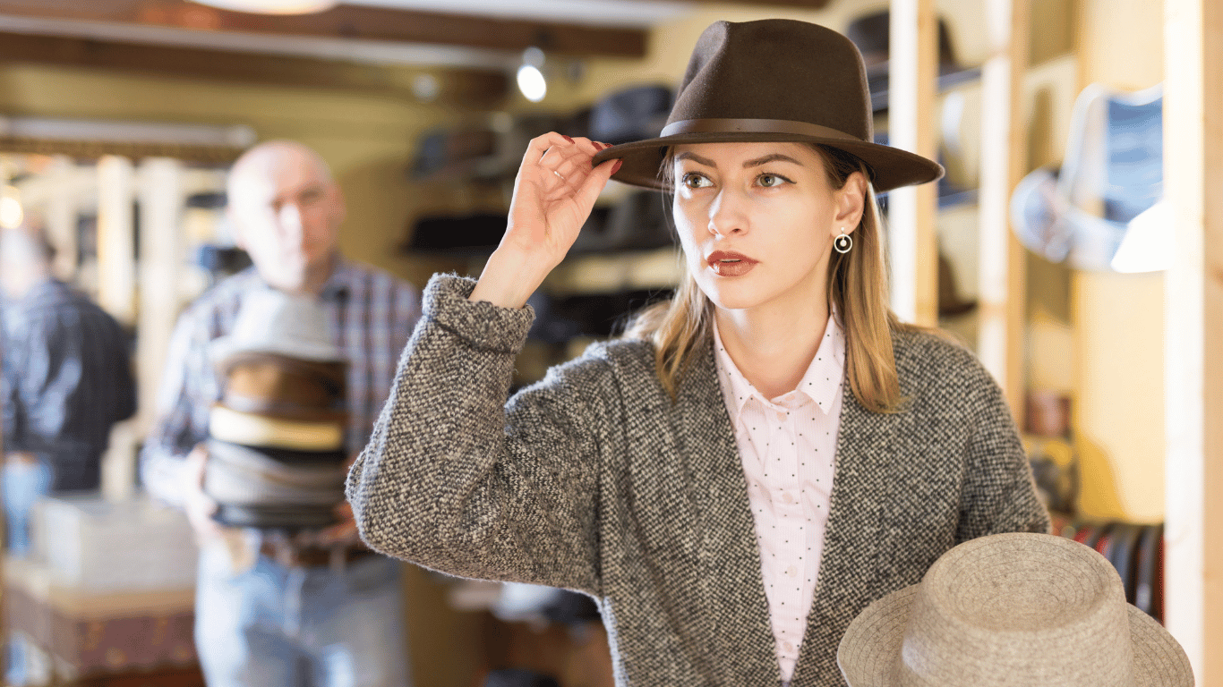 woman holding hat while looking on left side